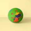 A green basketball with a purple cartoon dinosaur pattern printed on its surface, wearing a yellow headscarf with red dots, an orange outfit, and decorated with a small orange basketball and blue-green leaves Application Scenario